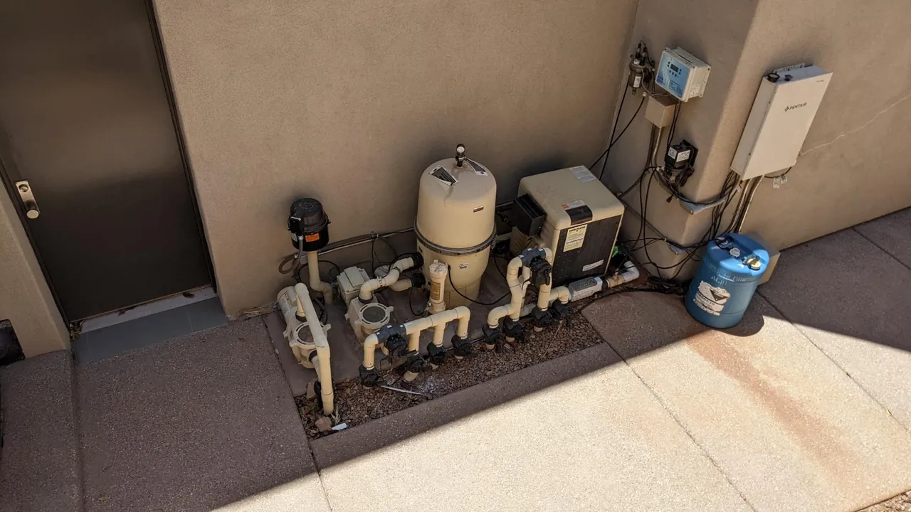 Pool equipment pad with pumps, filter, heater, valves and wall-mounted controls